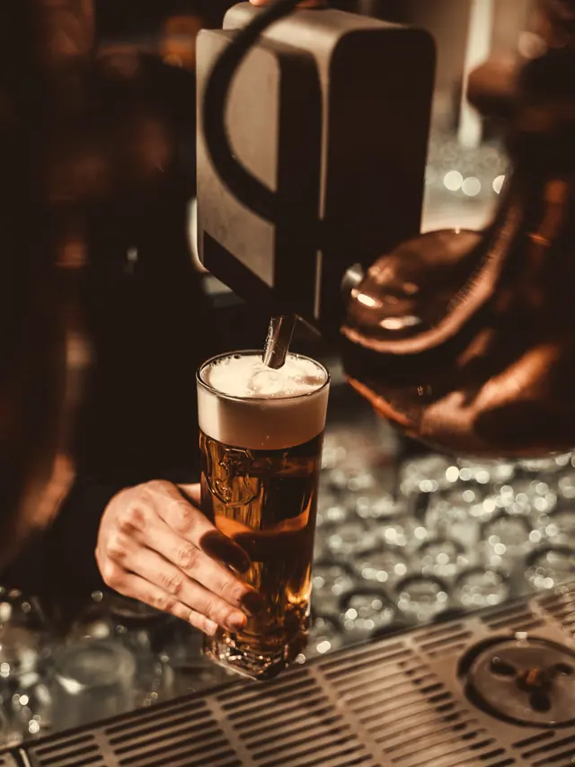 Barmanul umple o halbă direct de la robinet